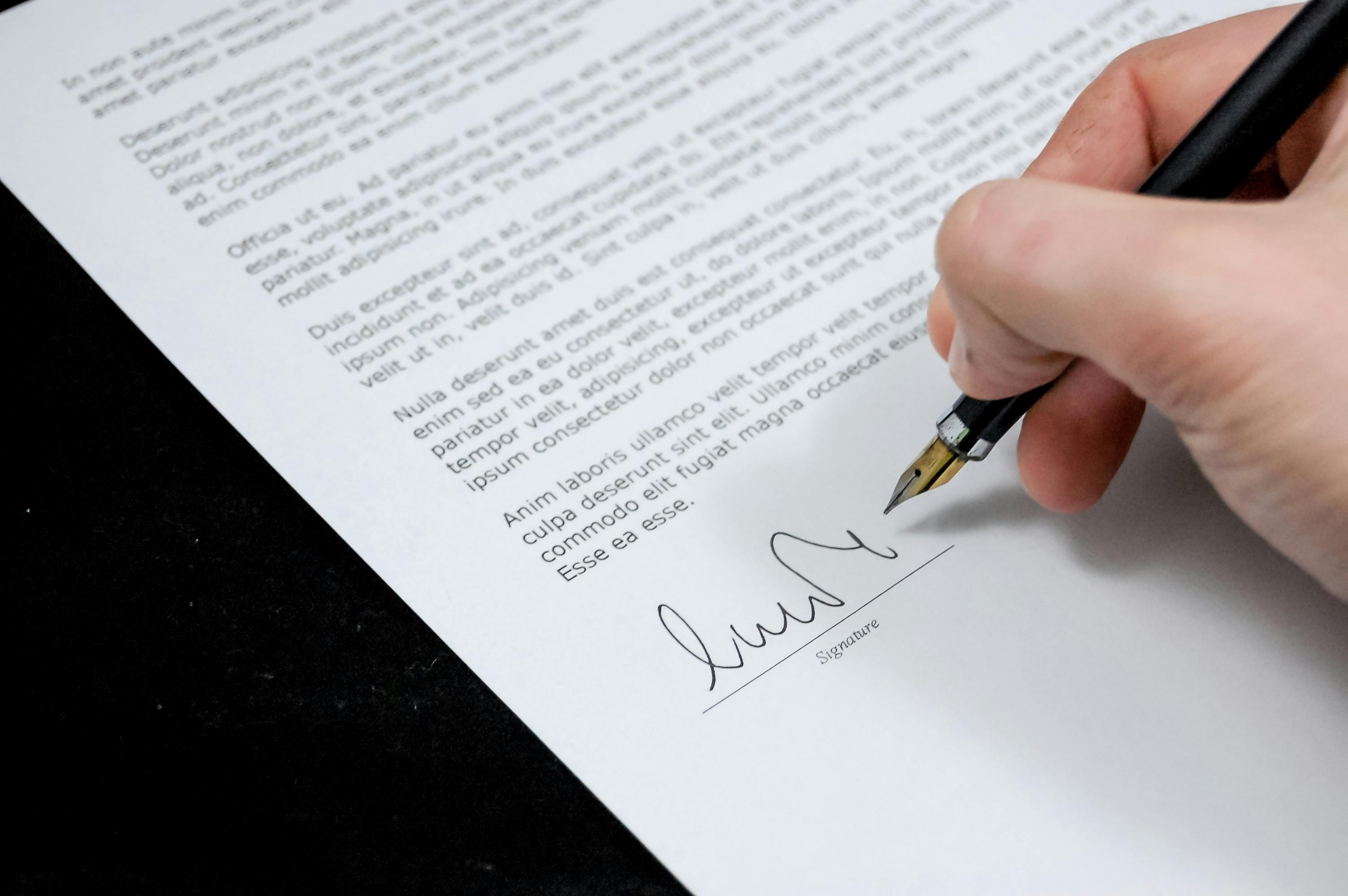 someone signing the bottom of a contract
